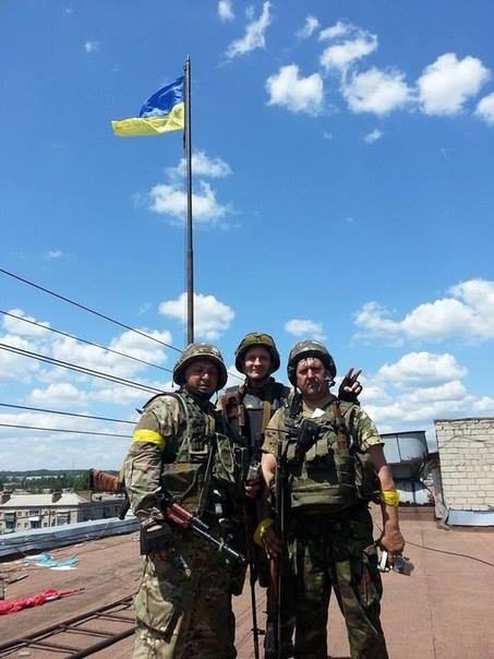 جنود أوكران يرفعون العلم الأوكراني فوق مبنى إدارة مدينة سلافيانسك