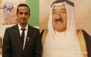 أحد أبناء الكويت يقف إلى جانب صورة أمير الدولة في ذكرى الاستقلال