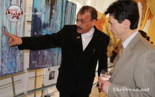فنان كويتي يستعرض لوحته لأحد ضيوف المعرض