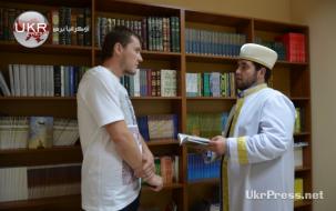 إمام يعرف أحد الأوكرانيين على مكتبة المركز وينصحه ببعض الكتب